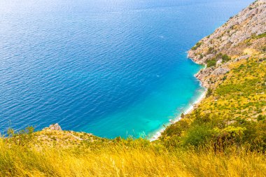 Sahil sahili turkuvaz mavi su dalgaları adaları dağ tepeleri kayalıklar ve Dubrovnik Neretva İlçesi Dalmaçya Bölgesi Hırvatistan 'da Akdeniz doğa bitkileri panoraması.