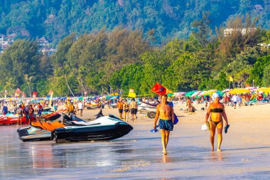 Kathu Bölgesi Phuket Adası, Tayland 05. Mart 2026 Patong Kamala Kumsalı Turistlerle su dalgaları güneş şemsiyeleri tropik bitkiler ve palmiye ağaçları Phuket Tayland 'da.