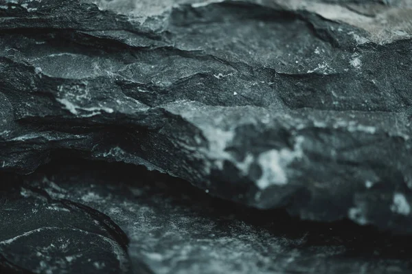 Black shale rock background, small depth of field close-up