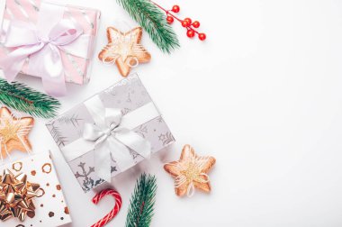 Beyaz arkaplanda yeni yıl arkaplanı, içinde böğürtlen, tatlı ve ağaç dalları bulunan kutular çerçevenin kenarında, yazıtlar için boş bir boşluk var..