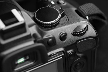 Bir SLR kameranın kontrol konsolunun bir parçası. Siyah bir arka planda parlak gölgeleri olan siyah siluet.
