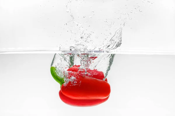 Красивый Красный Перец Колокольчика Падает Воду Красивыми Брызгами Белом Фоне — стоковое фото