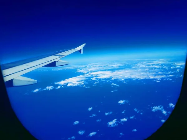 Pencere manzaralı mavi gökyüzünde uçak kuyruğu bulutlu 