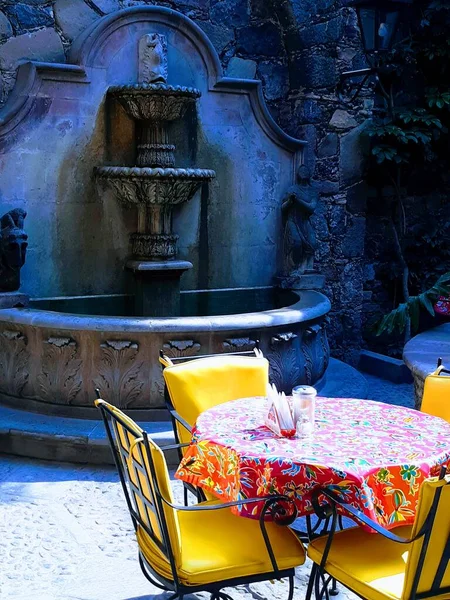 Tarihi San Miguel Allende 'de yemek masası ve çeşmesi olan antik bir avlu. 