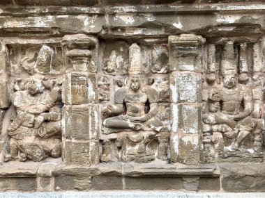 Hindu tanrısı heykeli. Antik kumtaşı tapınak duvarlarına tarihi Hindu tanrısı heykelleri oymuş. Kanchipuram, Tamilnadu 'daki Kanchi Kailasanathar Tapınağı' nda oyulmuş antik heykeller..