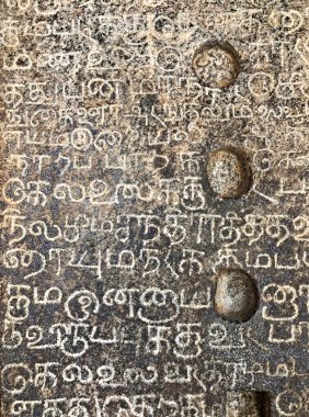Eski tapınak taş duvarlarındaki yazıtlar. Antik taş oymacılığı. Eski taş duvar dokusu. Tarihi tapınak duvarlarında Tamil yazıtları. Kanchipuram, Tamilnadu 'daki Kanchi Kailasanathar tapınağındaki taş yazıtlar..