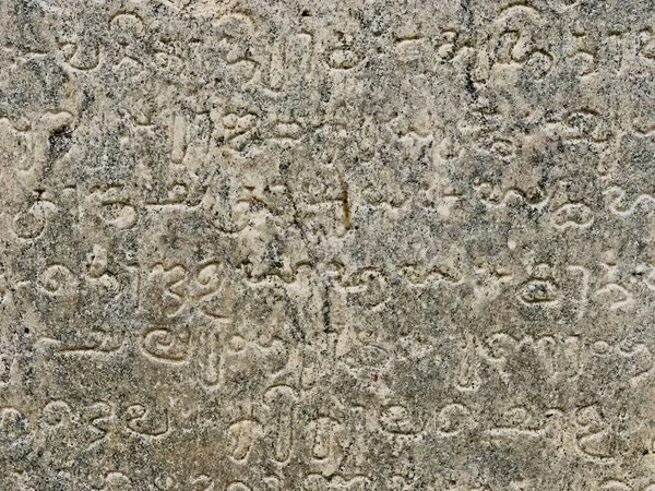 Inscriptions on the ancient temple stone walls. Ancient stone carving. Old stone wall texture. Tamil inscriptions in historical temple walls. Stone inscriptions in Kanchi Kailasanathar temple in Kanchipuram, Tamilnadu.