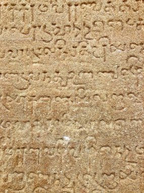 Eski tapınak taş duvarlarındaki yazıtlar. Antik taş oymacılığı. Eski taş duvar dokusu. Tarihi tapınak duvarlarında Tamil yazıtları. Kanchipuram, Tamilnadu 'daki Kanchi Kailasanathar tapınağındaki taş yazıtlar..