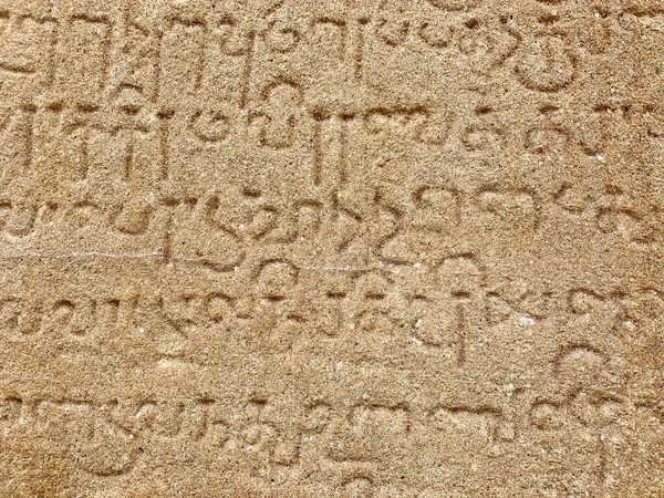 Inscriptions on the ancient temple stone walls. Ancient stone carving. Old stone wall texture. Tamil inscriptions in historical temple walls. Stone inscriptions in Kanchi Kailasanathar temple in Kanchipuram, Tamilnadu.