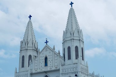 Sağlıklı Meryem Ana Bazilikası, Aziz Mary tapınağı mabedi, Aziz Mary Katedrali, kutsal üçleme cephesi. Velankanni 'de mavi gökyüzü arka planına karşı Roma Katolik Latin kilise kulesi.