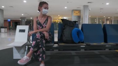 Coronavirus Pandemia nedeniyle havaalanında koruyucu maske takan genç bayan. İçerik: Seyahat, Kapsamlı 19 Seyahat, Boş Boşluklar.