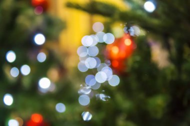 Süslemeleri ve ışıkları olan Noel ağacı, bulanık yeni yıl arkaplanı..