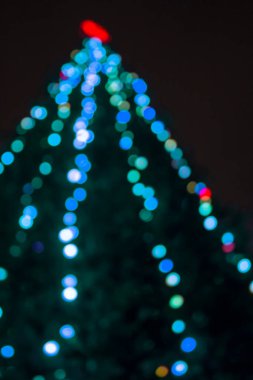 Bulanık bokeh ile soyut noel arkaplanı noel ağacı üzerindeki bulanık ışık süslemesi.