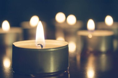 Mum ışıkları koyu arkaplanda. Mum ışığı, tatil arkaplanı. Bir sürü yanan mum..