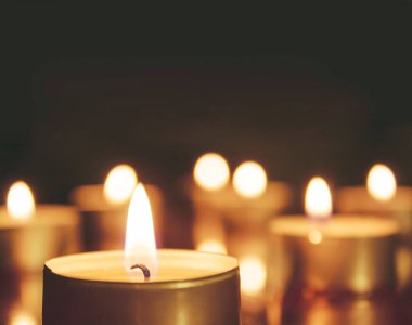 Mum ışıkları koyu arkaplanda. Mum ışığı, tatil arkaplanı. Bir sürü yanan mum..