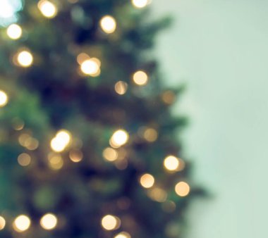 Odaklanamadığı bokeh ışıkları ve tatil geçmişi olan soyut bir noel ağacı..