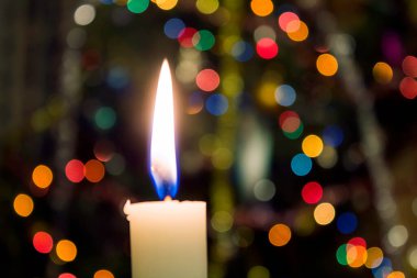 Odaklanamayan sahte Noel ışıklarında mum.