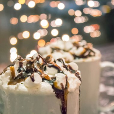 Lokum kaplı bir fincan sıcak çikolata ve arka plandaki kafede çikolata sosu..