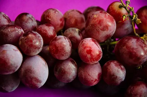 Eine Traube Roter Trauben Mit Einem Zweig Auf Violettem Hintergrund — Stockfoto