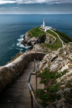 Güney Yığını Deniz feneri ve Kuzey Galler 'deki İrlanda Denizi manzaralı Güney Stack Adası' na uzanan dik adımlarla muhteşem bir yol.