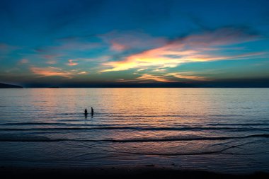 İngiltere 'nin Pembrokeshire Atlantik Sahili' nde güneş batarken Güney Galler 'deki Broad Haven plajında yaşayan çift.