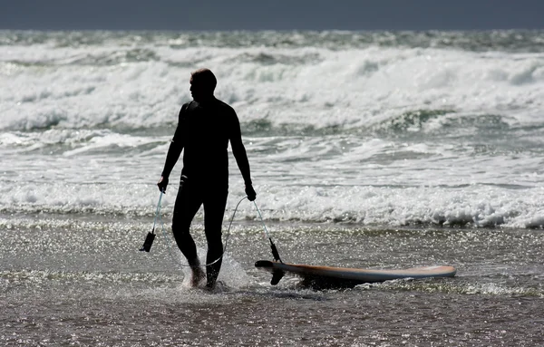Surfista dejando el agua en la costa irlandesa — Foto de Stock