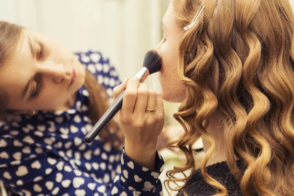 Morena compõem artista mulher aplicando maquiagem para uma noiva loira — Fotografia de Stock