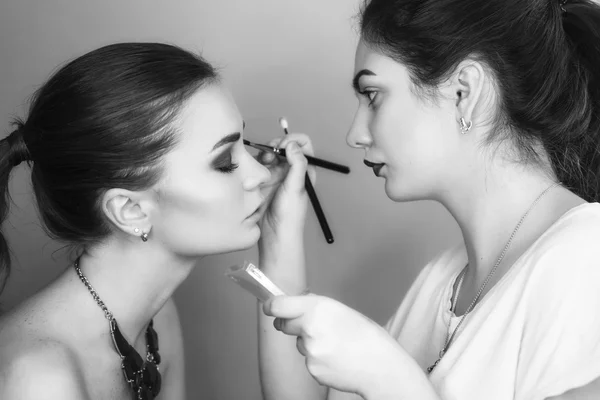 Brunette make up artist woman applying make up for a brunette br — Stock Photo, Image