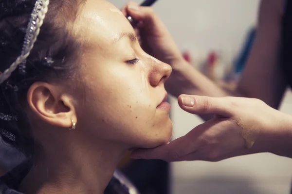 Make-up artiest vrouw make up solliciteert met een brunette model voor een — Stockfoto