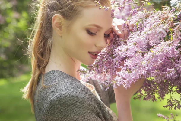 Beautiful red hair ginger slim young woman with fresh skin in casual outfit, posing with flowers. Sunny summer day in park (nature). Daylight — Stock Photo, Image