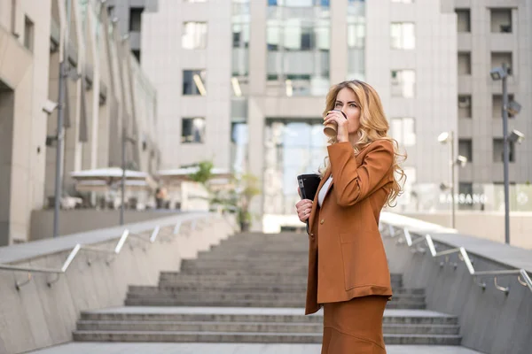 금발의 여성이 야외에서 있습니다 그녀는 커피를 마시며 여름의 온기를 즐긴다 — 스톡 사진