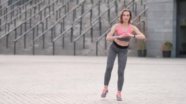 Ejercicio de mujer adulta en forma delgada en un entrenamiento al aire libre solo. Atardecer de verano retratos matutinos en acción en calles europeas con espacio para el texto — Vídeos de Stock