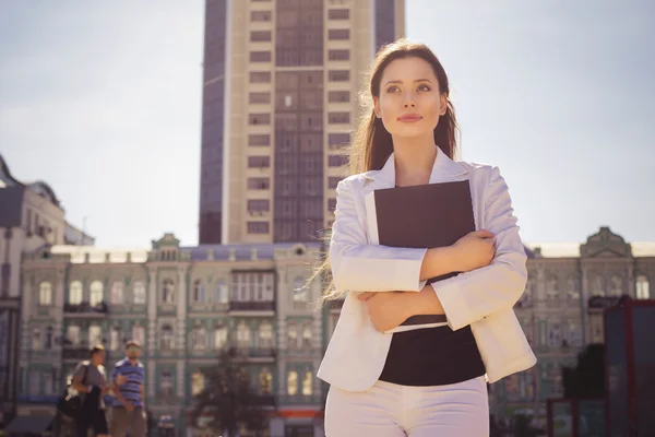 Beautiful brunette business woman in white suit with folder of d — Stock Photo, Image