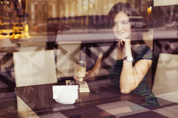 Brunette woman sitting at the cafe reading book, studing and drinking coffee and talking on the phone. Copy Space — Stock Photo, Image