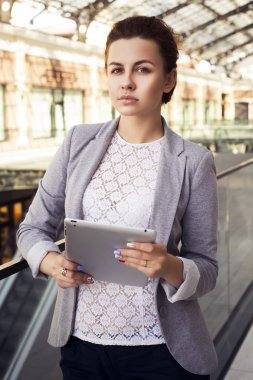 güzel esmer kadın gri ceket, pantolon koyu ve açık havada tablet ile beyaz bluz