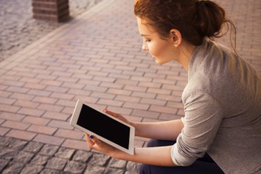gri ceket, karanlık pantolon ve beyaz bluz ile tablet açık havada güzel esmer kadın. kopya alanı