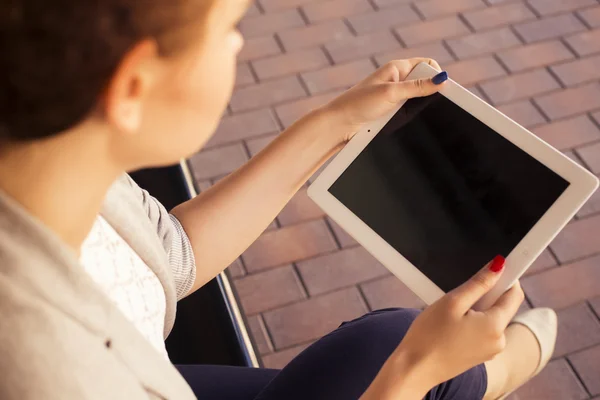 Belle femme brune en veste grise, pantalon foncé et chemisier blanc avec tablette à l'extérieur. Espace de copie — Photo