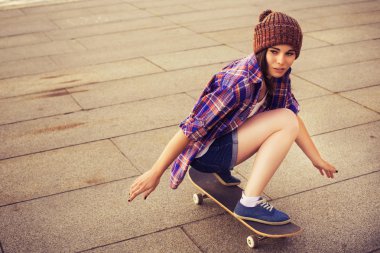 iki esmer genç kız arkadaş hipster kıyafeti (kot şort, keds, ekose gömlek, şapka) vasıl belgili tanımlık park açık havada kaykay. kopya alanı