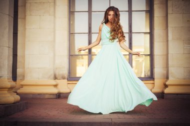 güzel sarışın uzun kıvırcık saçları uzun Abiye retro vintage yaz günbatımı bina yakınındaki açık havada hareket içinde. kopya alanı