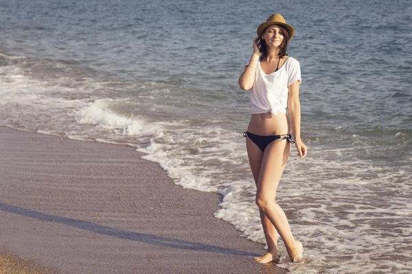 水に探している海の近くの砂の海岸に立っている女性 — ストック写真