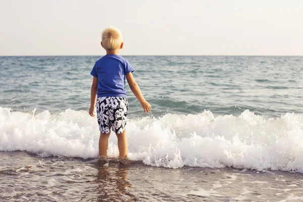 Mały chłopiec dziecko grając w wodzie morskiej na plaży. miejsce — Zdjęcie stockowe