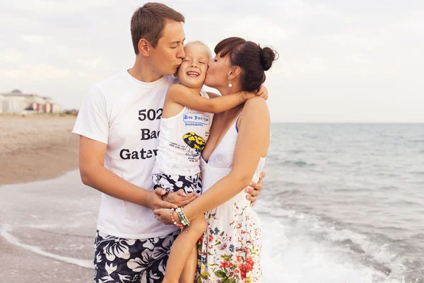 Familia de pie en una playa de arena cerca del mar jugando en el wate — Foto de Stock