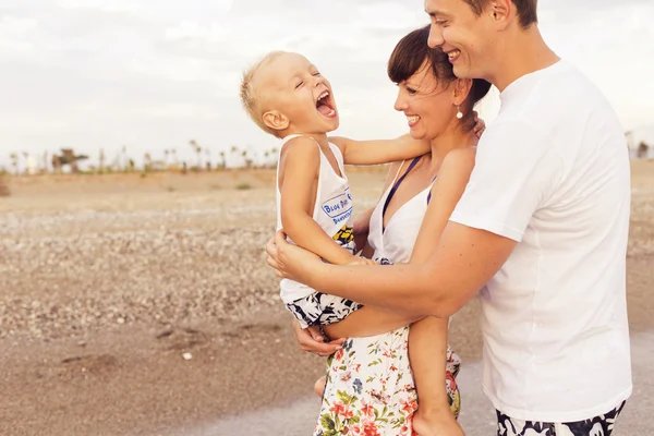 Familia de pie en una playa de arena cerca del mar jugando en el wate — Foto de Stock