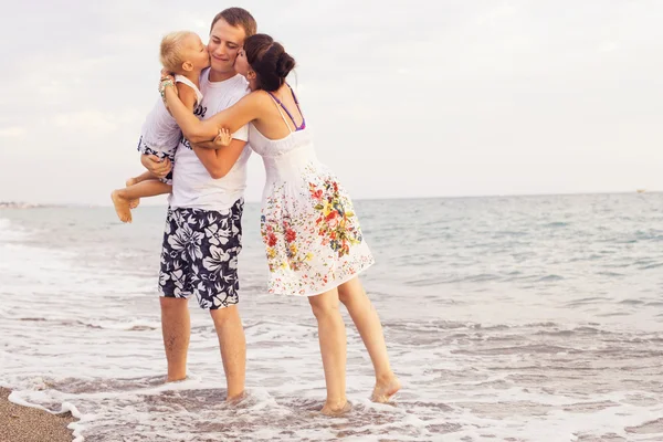 Familia de pie en una playa de arena cerca del mar mirando a cada oth —  Fotos de Stock