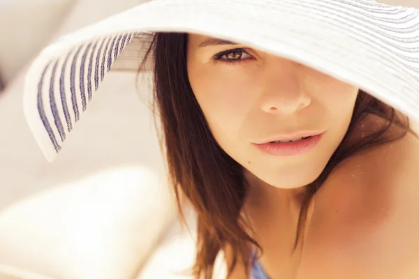 Beautiful brunette woman on the beach alone relaxing in a hat. S — Stock Photo, Image