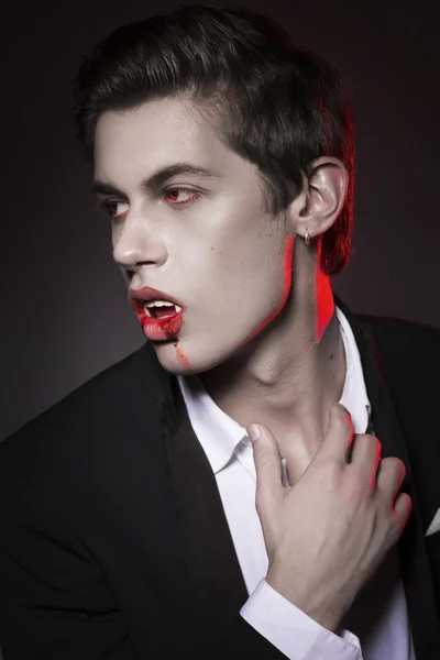 Young sexy man dracula vampire with red eyes and fangs, mouth co — Stock Photo, Image