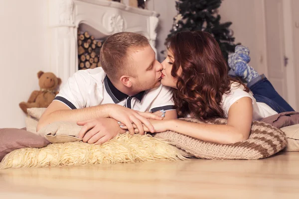 Amor pareja celebrando la Navidad y el año nuevo en casa sentado —  Fotos de Stock