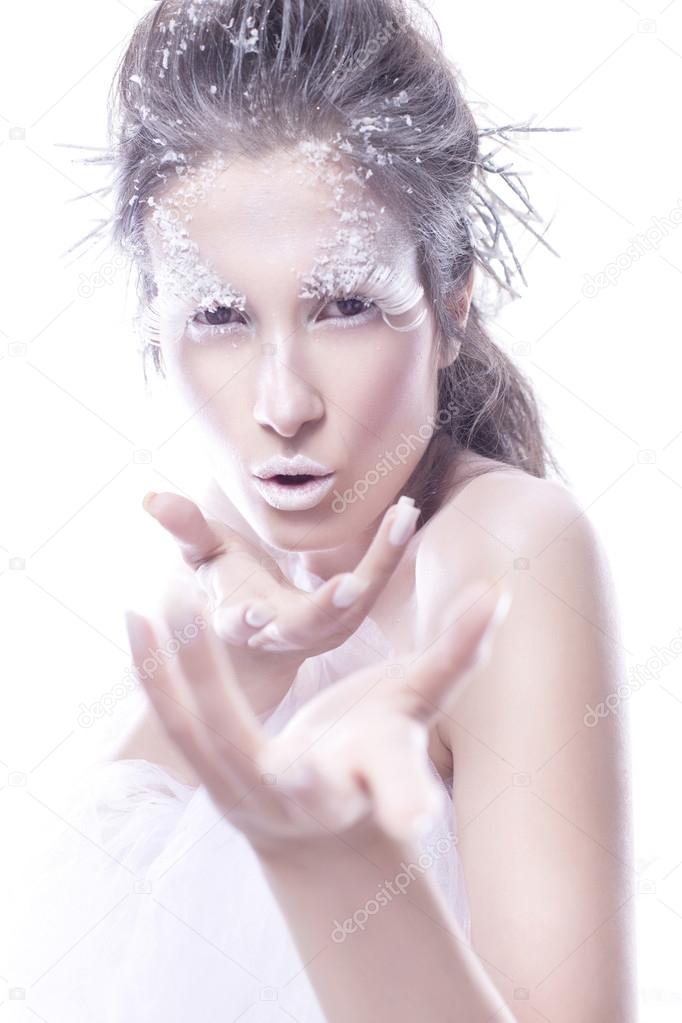 Brunette woman with creative make up in winter style with white 