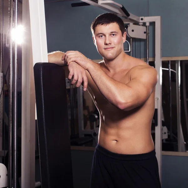 Fit man trains in gym. alone. one. indoors — Stock Photo, Image