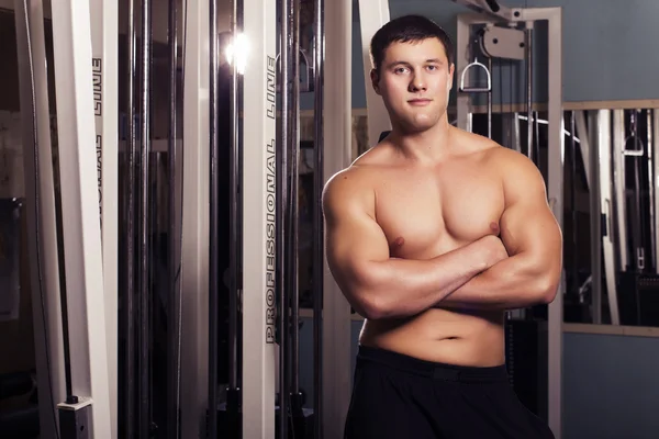 Fit man trains in gym. alone. one. indoors — Stock Photo, Image